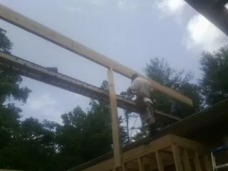 Carpenter setting a ridge beam over a new addition frame — Ice Dam Removal by Roofing Brothers in Hatch