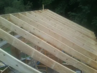 New roof rafters set over an addition before sheathing in Hatch
