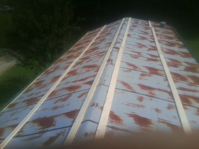 Rusted metal roof panels with new wood purlins before replacement — Storm Damage Roof Repair in Hatch by Roofing Brothers