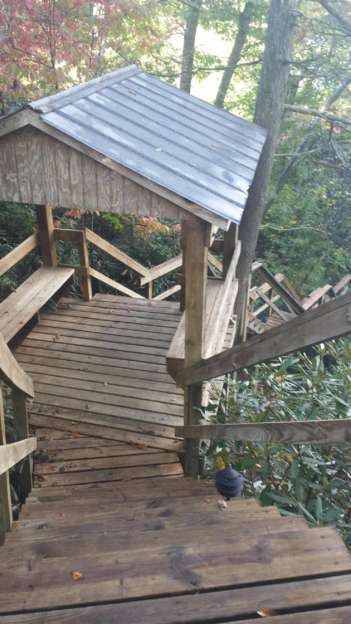Metal roofed shelter over wooden steps on a wooded walkway — Skylight Repair & Installation work by our crew in Hatch