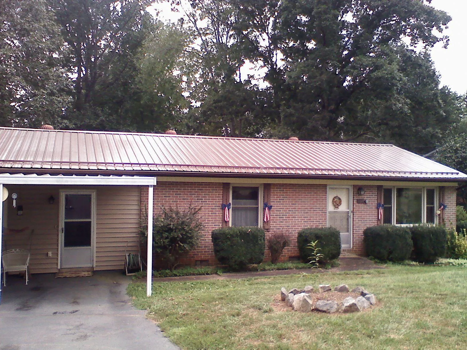 Bronze metal roof and carport on a brick ranch home — Roof Repair work by our crew in Hatch